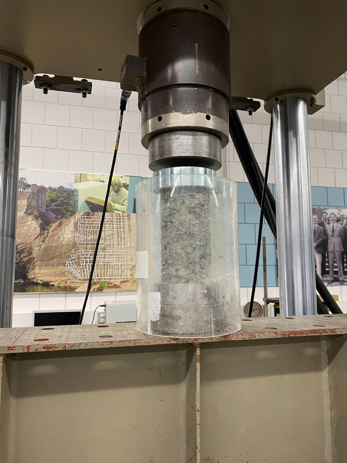 MTS 810 load frame testing a PLA concrete aggregate cylinder until failure